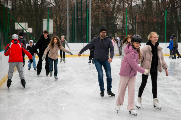 Młodzież na lodowisku jeżdżąca na łyżwach 