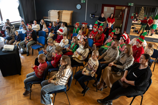 Widownia podczas wykładu dotyczącego bankowości. Dzieci w strojach elfów, towarzyszący im rodzice 