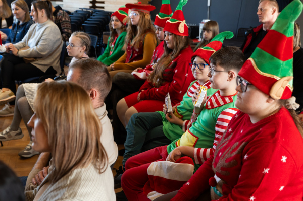 Widownia podczas wykładu dotyczącego bankowości. Dzieci w strojach elfów, towarzyszący im rodzice 
