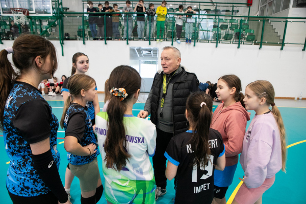 Drużyna dziewcząt zebrana wokół trenera 