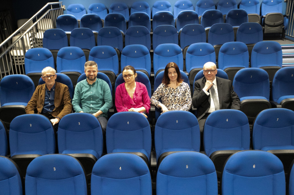 Pracownicy i dyrekcja CKis wraz z twórcami filmu na pustej sali kinowej po projekcji. 