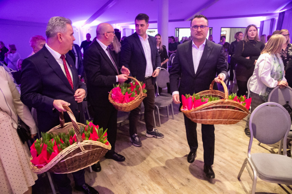 Przedstawiciele władz wręczają paniom kwiaty 