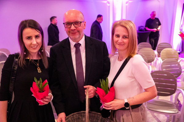 Jan Bereza z dwiema kobietami i kwiatami 