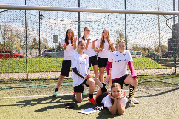 Zawodniczki pozują na tle bramki